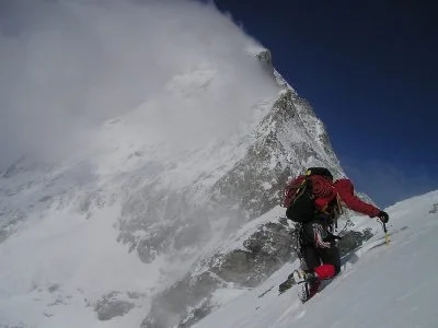 A mountaineer climbing a steep snow-covered mountain