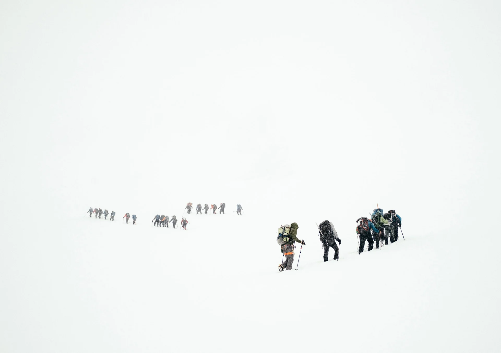 A line of expedition walkers crossing an open snowfield