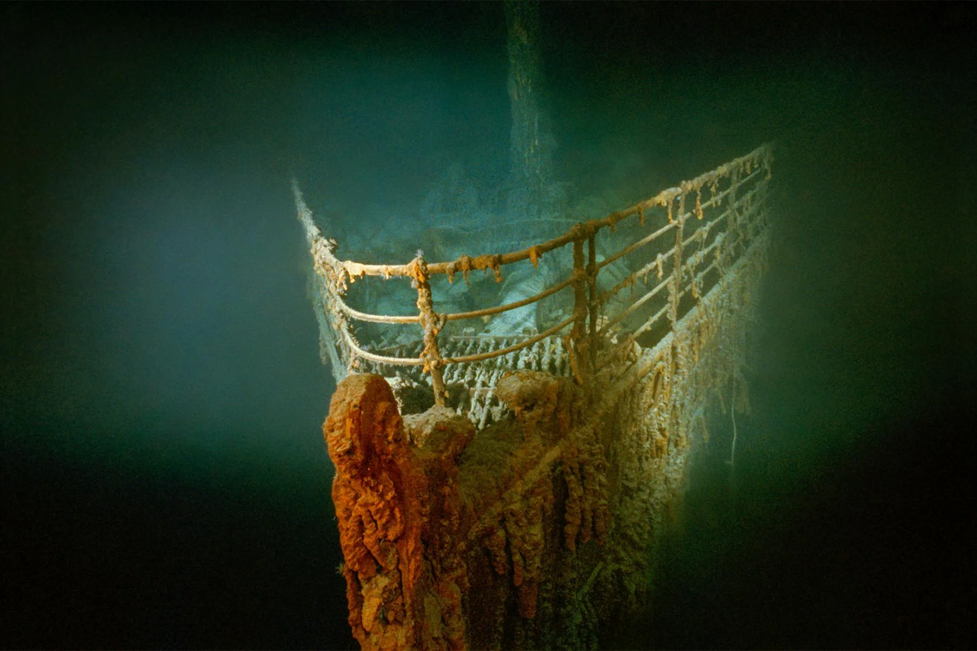 The rust-covered bow of Titanic illuminated on the ocean floor